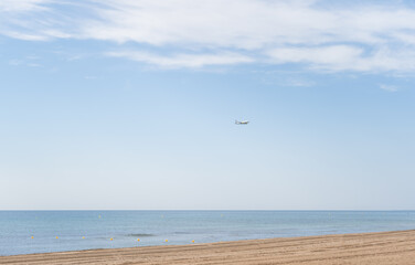 Airplane landing above beautiful beach and sea background