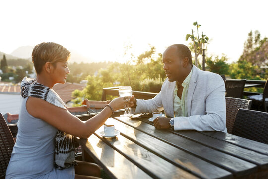 Happy Multiracial Couple Drinking Cocktails On A Summer Sunny Sunset Day, Multicultural Couple And Family Concept. 