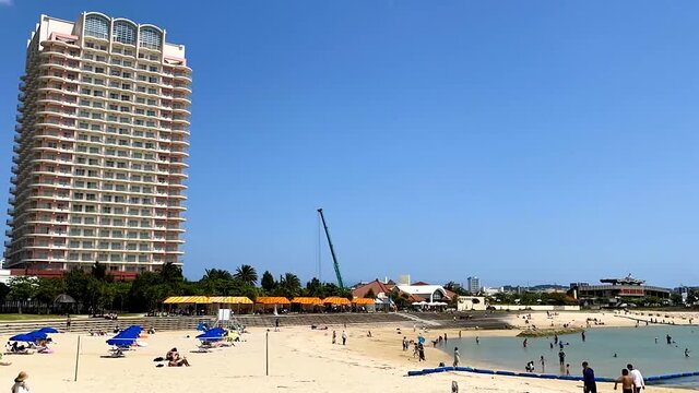 CHATAN-CHO, OKINAWA, JAPAN - JUNE 2021 : View of Chatan sunset beach (Ocean or sea). Wide view, time lapse tracking shot in daytime. Holiday, vacation and resort concept shot.