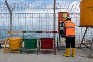 DENPASAR,BALI-DEC 24 2020: A construction project worker is resting and washing his hands. COVID 19 makes people have to obey health protocols, one of which is washing hands
