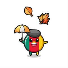 cartoon of the cute cameroon flag badge holding an umbrella in autumn