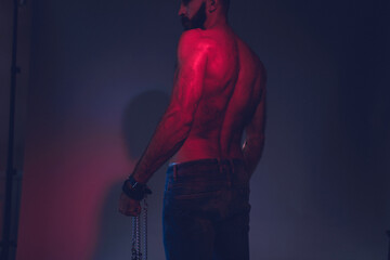 Portrait of a brutal bearded man with a naked torso.