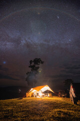 Yellow tent camping on hill under the milky way and starry in the night sky