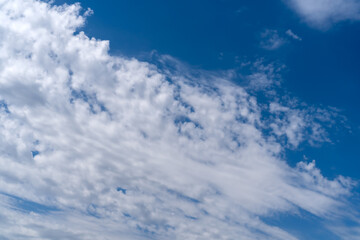 White feather clouds on blue sky