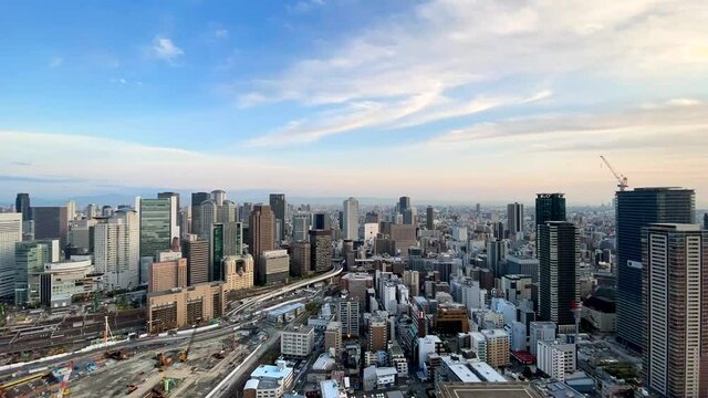 UMEDA, OSAKA, JAPAN : Aerial high angle sunrise view of CITYSCAPE of OSAKA. View of buildings and street around Osaka and Umeda station. Wide view time lapse shot, night to morning.