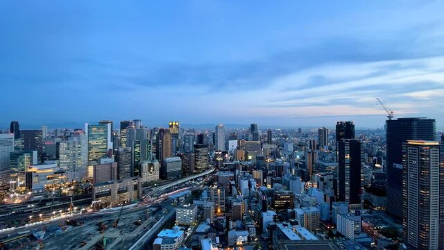 UMEDA, OSAKA, JAPAN : Aerial high angle sunrise view of CITYSCAPE of OSAKA. View of buildings and street around Osaka and Umeda station. Wide view time lapse shot, night to morning.