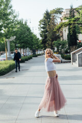 beautiful blonde woman dancing to music on the street alone