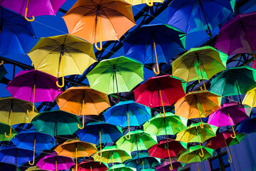 Obraz premium Colorful umbrellas in the evening. Colorful umbrellas in the sky. Street decoration from umbrellas. Background of umbrellas. 