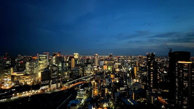 UMEDA, OSAKA, JAPAN : Aerial high angle sunrise view of CITYSCAPE of OSAKA. View of buildings and street around Osaka and Umeda station. Wide view time lapse shot, night to morning.