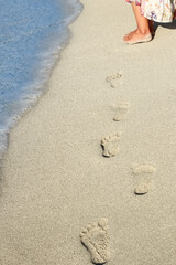 beautiful footprints with feet on the sand background