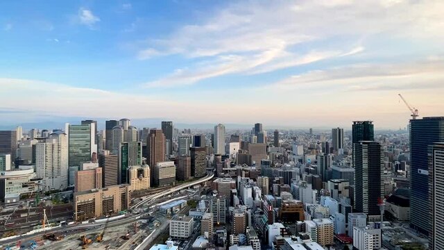 UMEDA, OSAKA, JAPAN : Aerial high angle sunrise view of CITYSCAPE of OSAKA. View of buildings and street around Osaka and Umeda station. Wide view time lapse zoom in shot, night to morning.