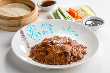 Peking Duck Chinese food with hoisin sauce, pancakes, cucumber and spring onions isolated on white background