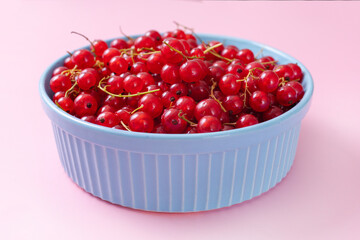 Fresh red currant in wooden bowl on dark table