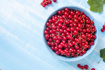 Fresh red currant in wooden bowl on dark table