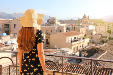 Young lady looking Palermo cityscape from balcony at sunset in Italy