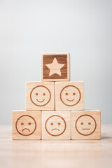 emotion face and Star symbol blocks on table background. Service rating, ranking, customer review,...