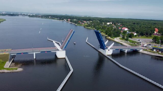 Open drawbridge to Sobieszewo island. Ships are sailing under the bridge over Dead Vistula river in Poland.