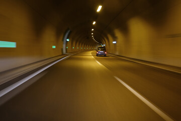 small car passing through motorway tunnel motion blur