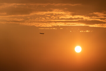 Das Flugzeug gegen die untergehende Sonne kurz nach dem Start