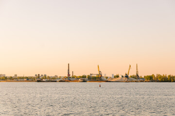 The Bulk carrier is loaded by coal on the anchorage of the port. An empty moored barge is waiting...