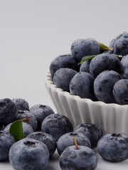 Blueberry fruit top view isolated on a white background, flat lay overhead layout with mint leaf, healthy design concept.