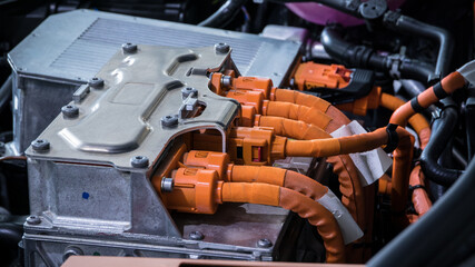 Powerful orange cables connecting the electric vehicle engine, inverter, traction battery and air...