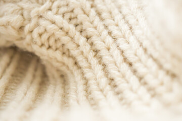 closeup beige knitted woolen fabric background