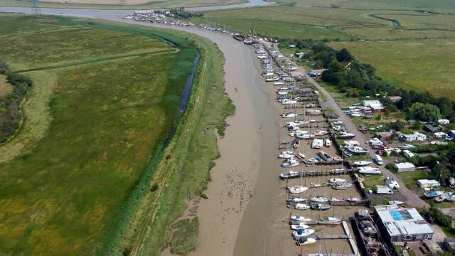 4K aerial video of low tide at a creek with boats and blue stream