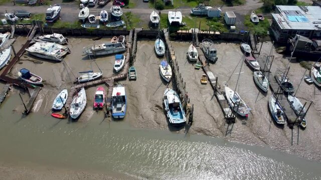 4K drone video of private boats in a repair yard at very low tide