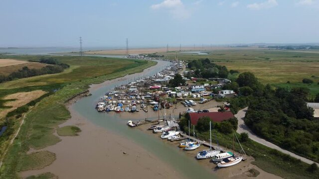 4K drone video flying away from a lot of boats in a creek