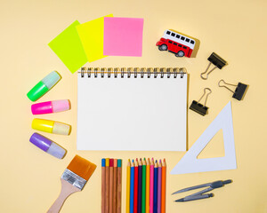 School accessories with a white sheet of notebooks and a place for text. Colors, markers, school supplies.