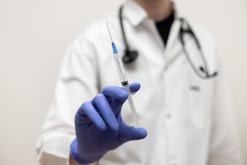 Vaccination. Doctor with a syringe on a white background close up. Coronavirus, covid-19 prevention.