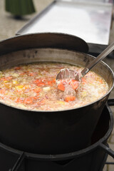 meat soup with herbs and spices boils over the fire