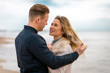 Obraz premium Two Young couple standing enjoying on a coast and enjoying each other.Summer,spring,autumn vacation.