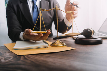 Business and lawyers discussing contract papers with brass scale on desk in office. Law, legal services, advice, justice and law concept picture with film grain effect