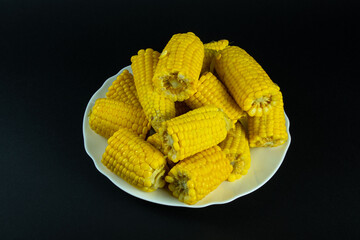 Boiled corn on a black background