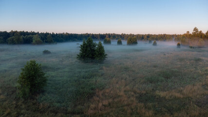 Foggy landscape of the valley during the sunrise. Beautiful bright morning time in the countryside