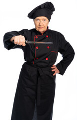 woman chef in black uniform. apron, shirt, hat. An elderly woman is holding a knife. threatens us. white background isolated