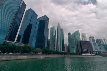 A pond in front of an esplanade against skyscrapers and a sky by spring day