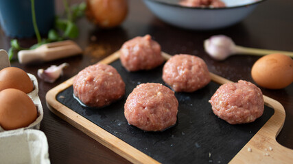 Turkey meatballs baked in the oven with herbs made by a girl according to a recipe from the Internet. Swedish meatballs cooking at home.