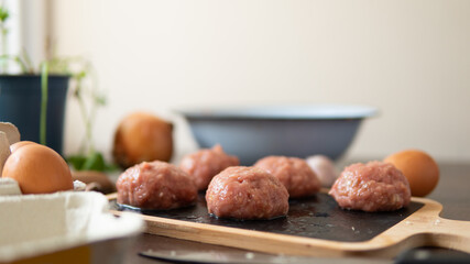 Turkey meatballs baked in the oven with herbs made by a girl according to a recipe from the Internet. Swedish meatballs cooking at home.