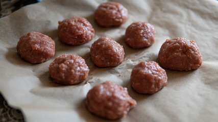 Turkey meatballs baked in the oven with herbs made by a girl according to a recipe from the Internet. Swedish meatballs cooking at home.