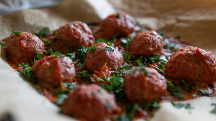 Turkey meatballs baked in the oven with herbs made by a girl according to a recipe from the Internet. Swedish meatballs cooking at home.