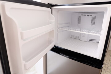 Empty fridge interior, selective focus. Clean refrigerator and freezer shelves close up. It is called 