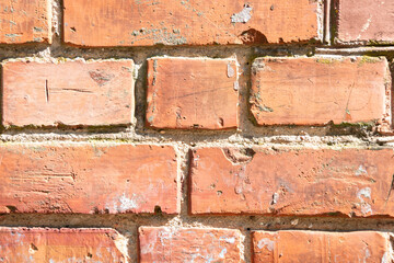 Obraz premium Fragment of a brick wall with layers of cement. Brick background. Close-up.