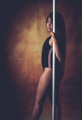 young asian woman doing pole dance at home