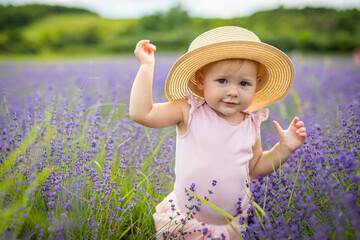 Smiling baby girl in pink dress in a lavender field, Czech republic