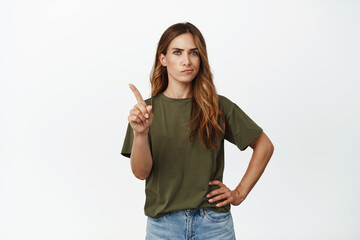 Very bad. Adult woman, mother shaking finger and smirk upset, disapprove smth upsetting, scolding person, not so fast gesture, standing in tshirt against white background