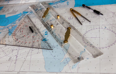 Maps of the ship for plotting. Plotter, divider, ruler and pen. Close-up. - obrazy, fototapety, plakaty