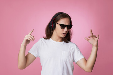 man in sunglasses listens to music with headphones and dances